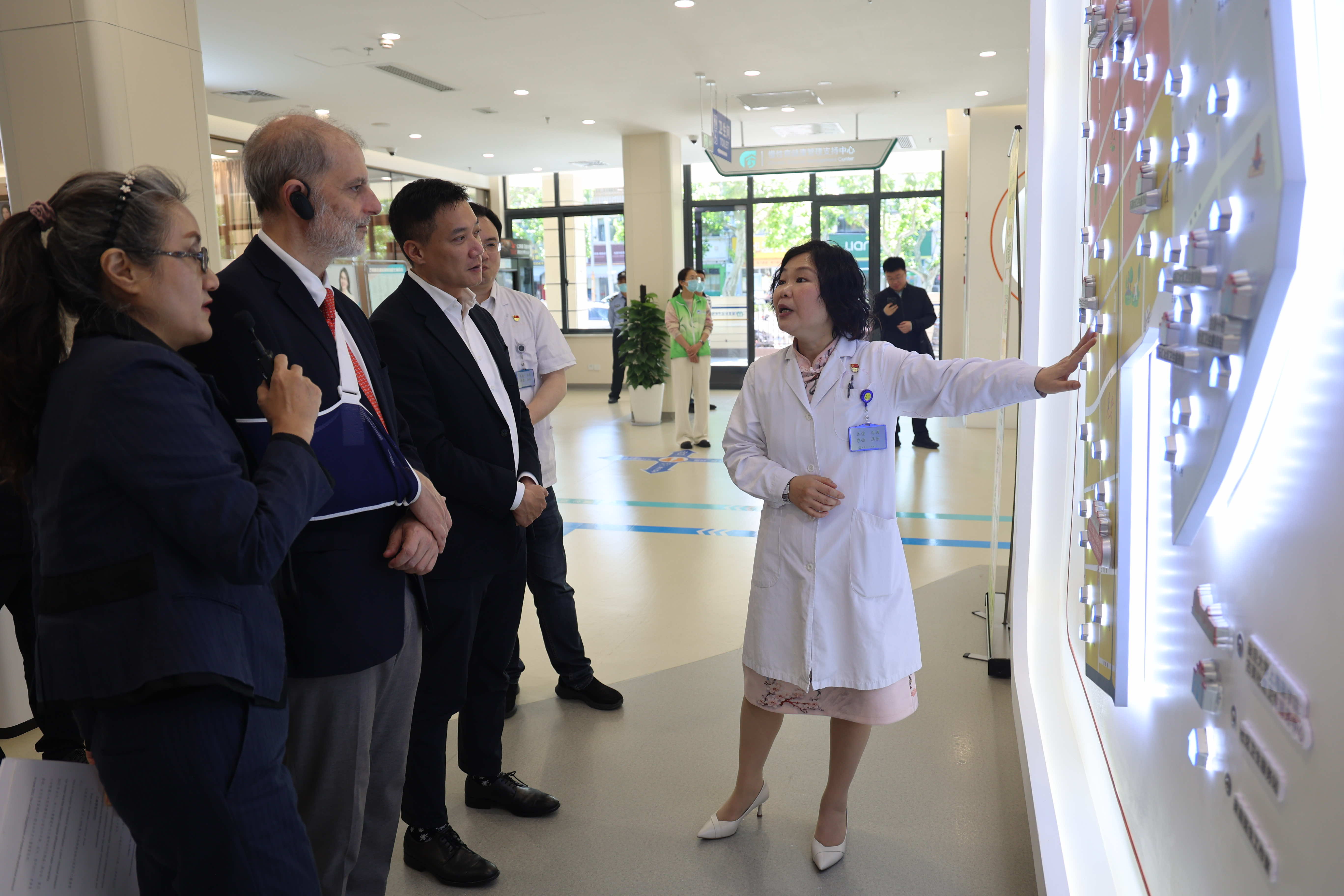 A Gumei Community Health Service Centre clinician shows WONCA assessors the centre's digital service platform display